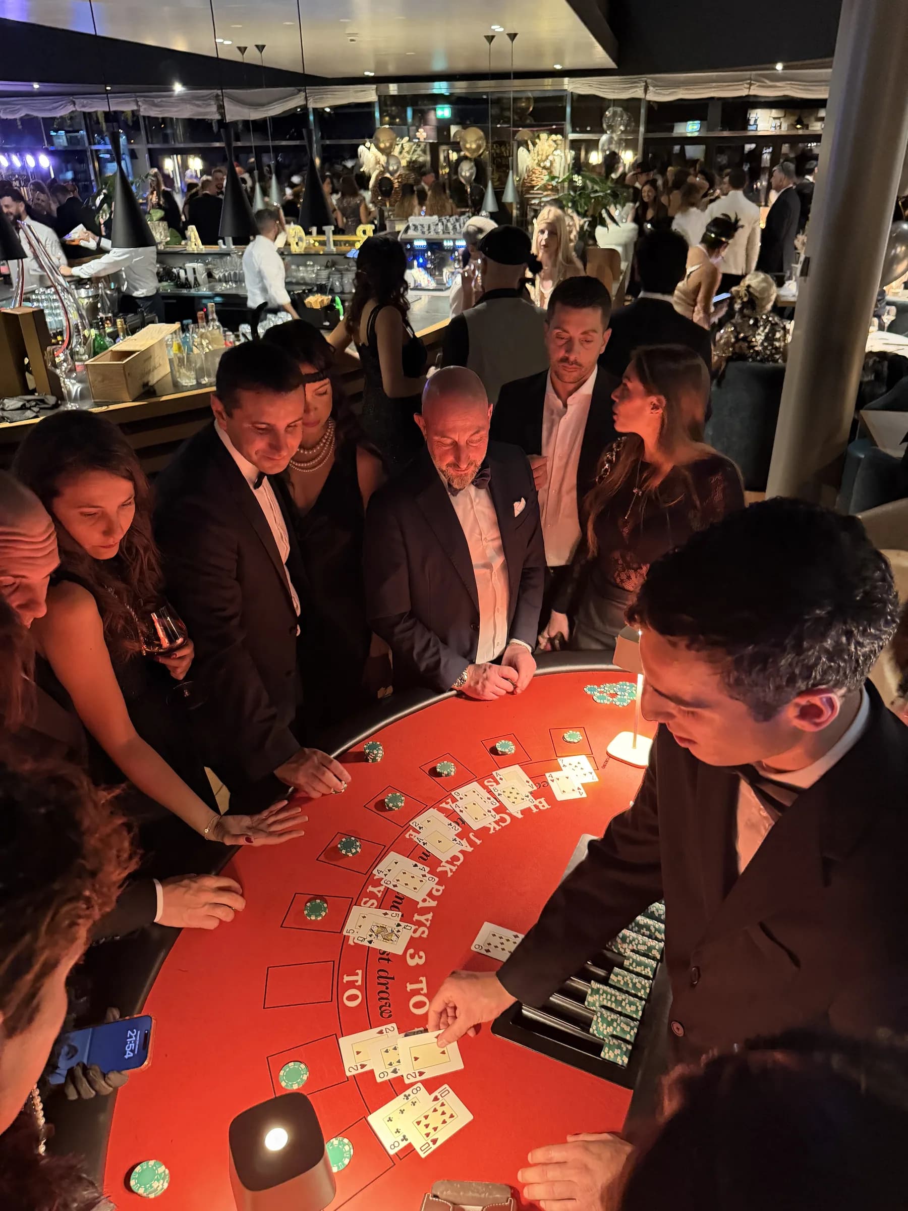 Ospiti e croupier al tavolo da blackjack durante una mano