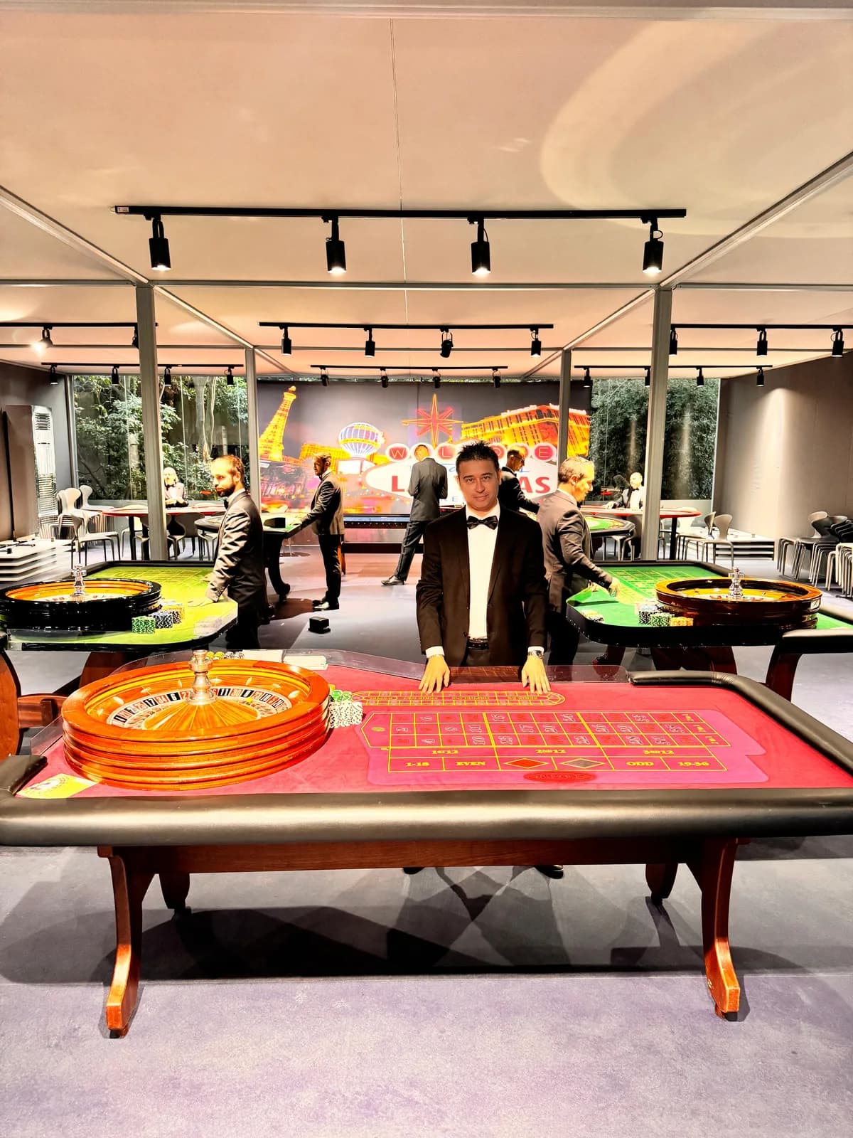 Croupier Fun Casinò a un tavolo da roulette in un allestimento con più tavoli