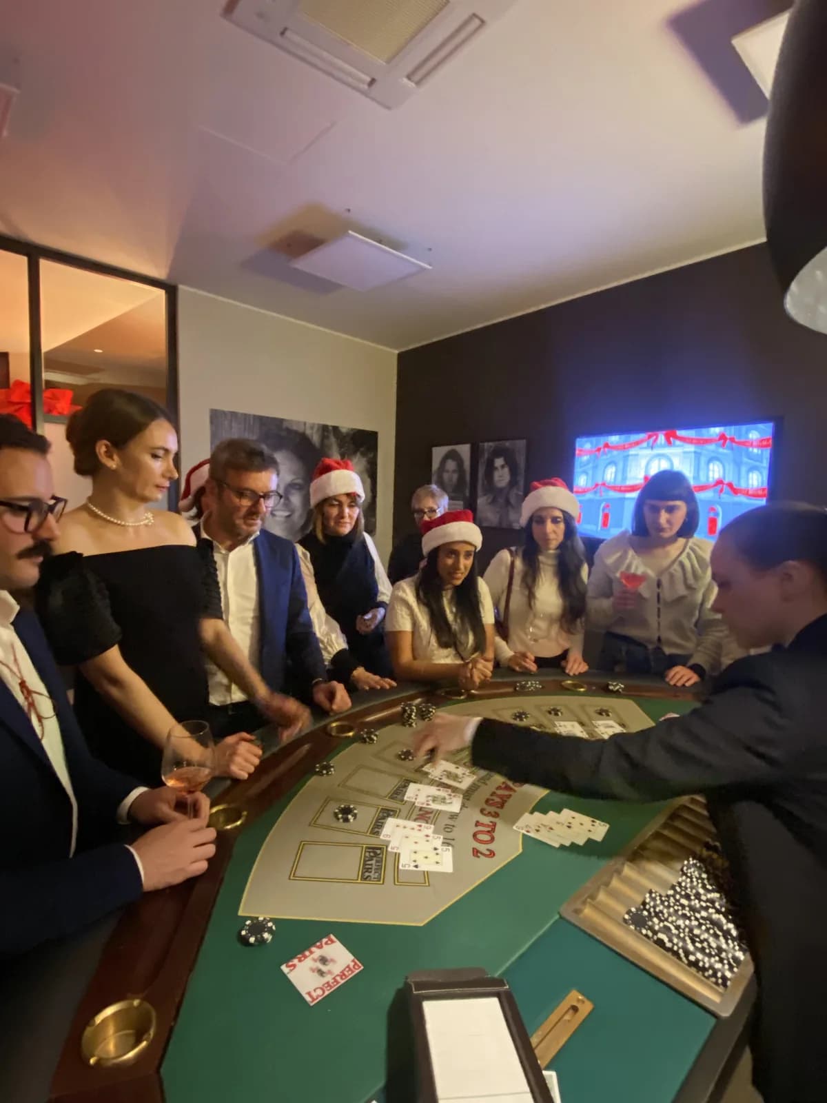 Ospiti e croupier intorno a un tavolo da carte in un interno durante un evento Fun Casinò