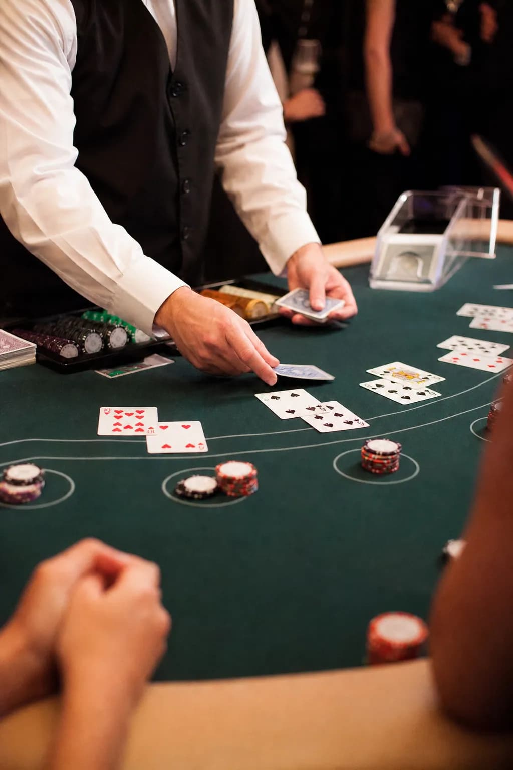 Croupier Fun Casinò che distribuisce carte su un tavolo da blackjack con fiches e ospiti
