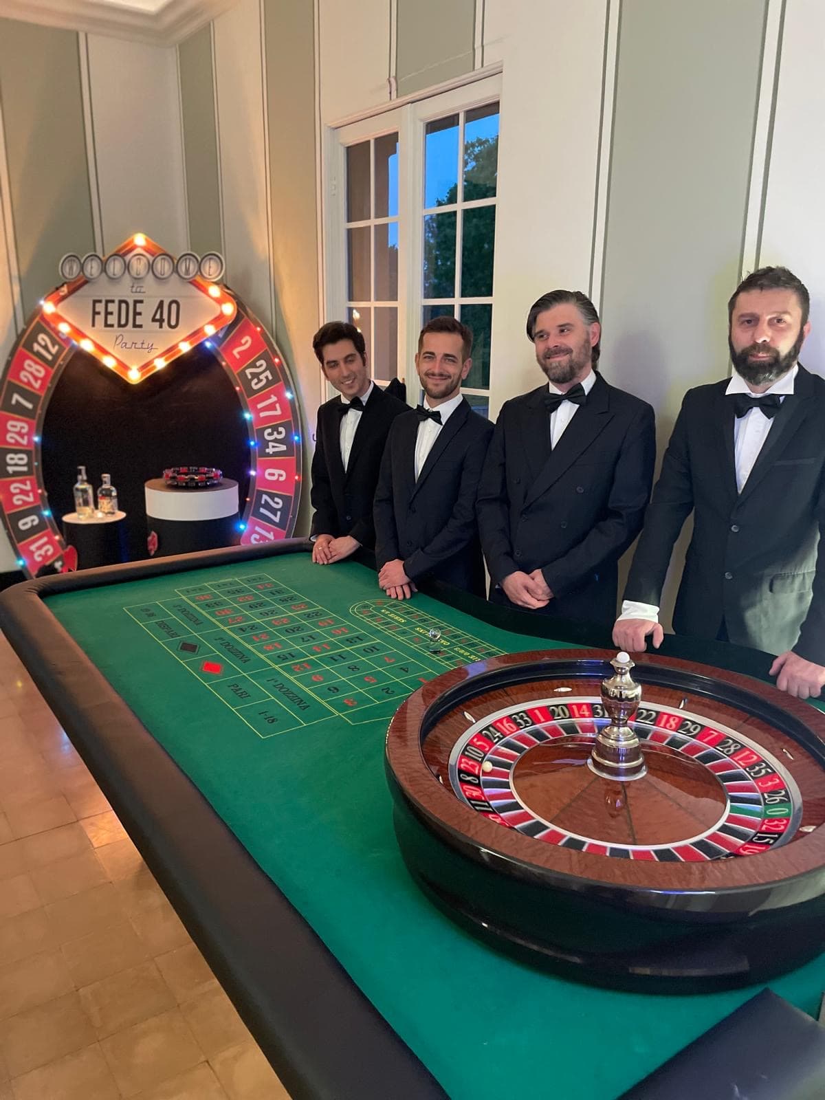 Quattro croupier Fun Casinò in smoking a un tavolo da roulette, durante una festa privata