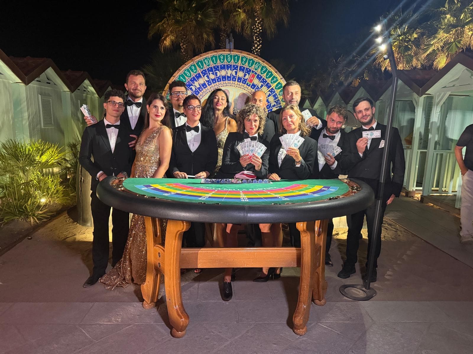 Squadra Fun Casinò intorno a un tavolo da roulette all’aperto, di sera