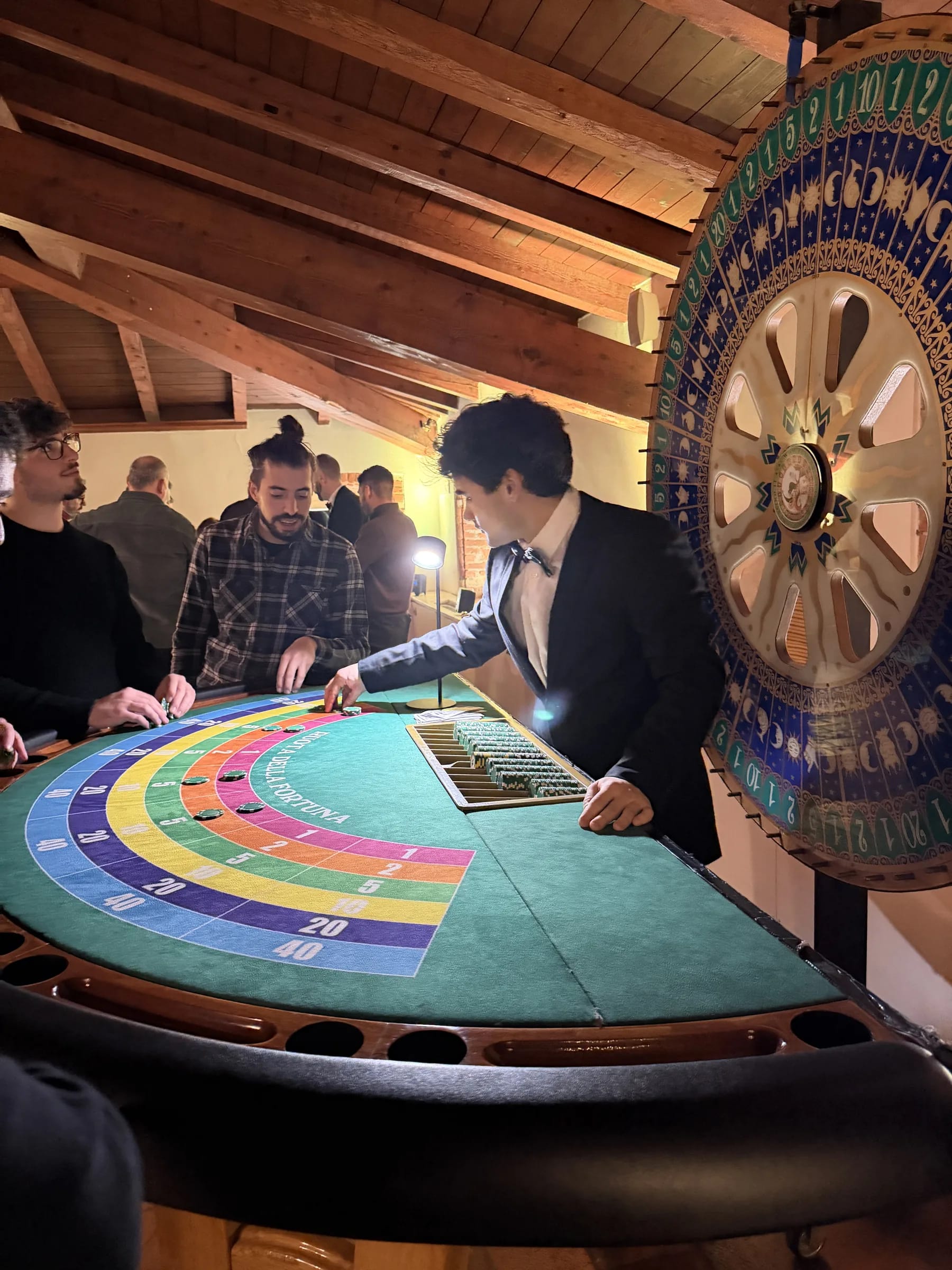 Ospiti al tavolo della ruota della fortuna mentre il croupier sistema le puntate