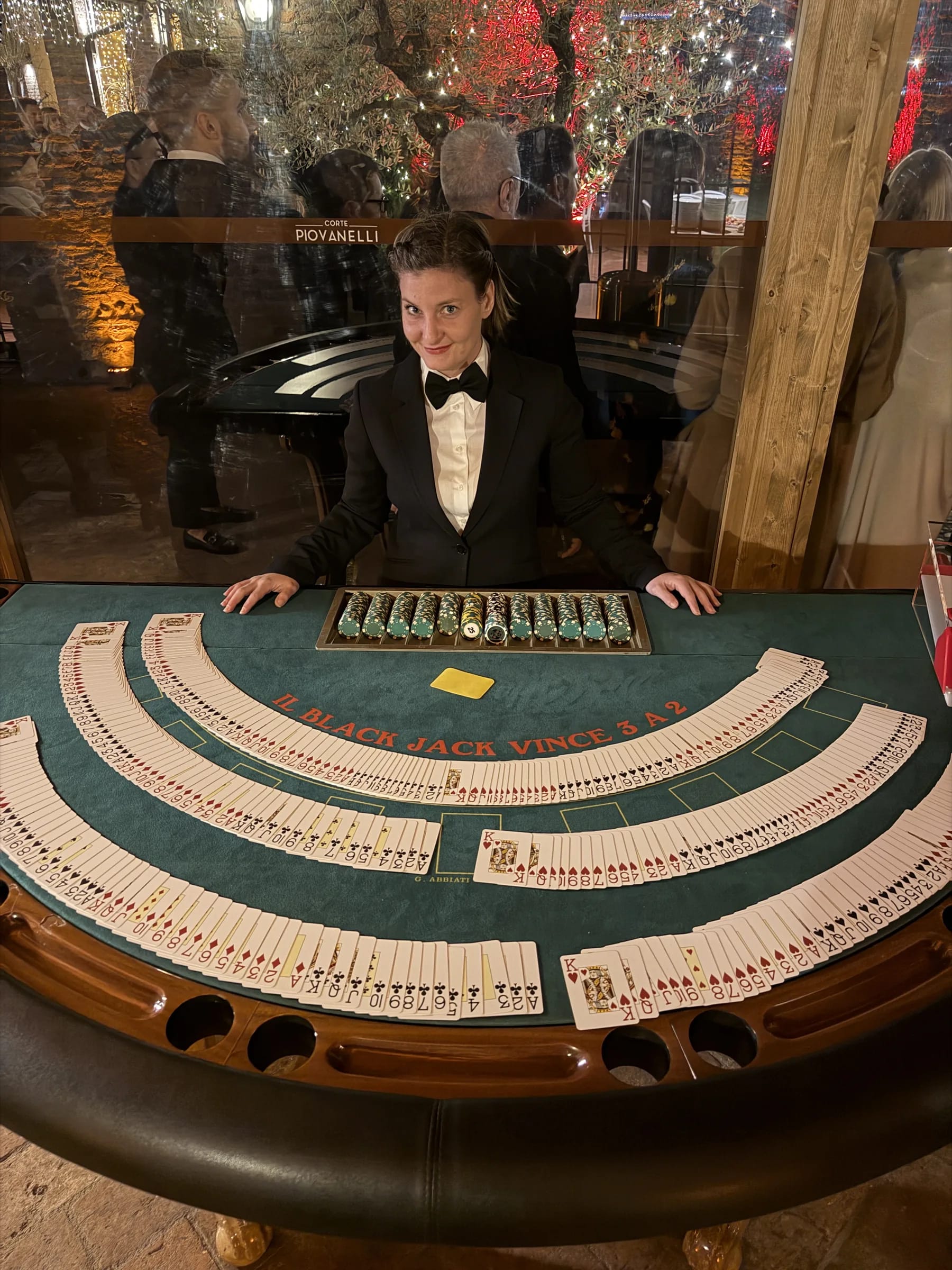Croupier con le carte a ventaglio al tavolo da blackjack