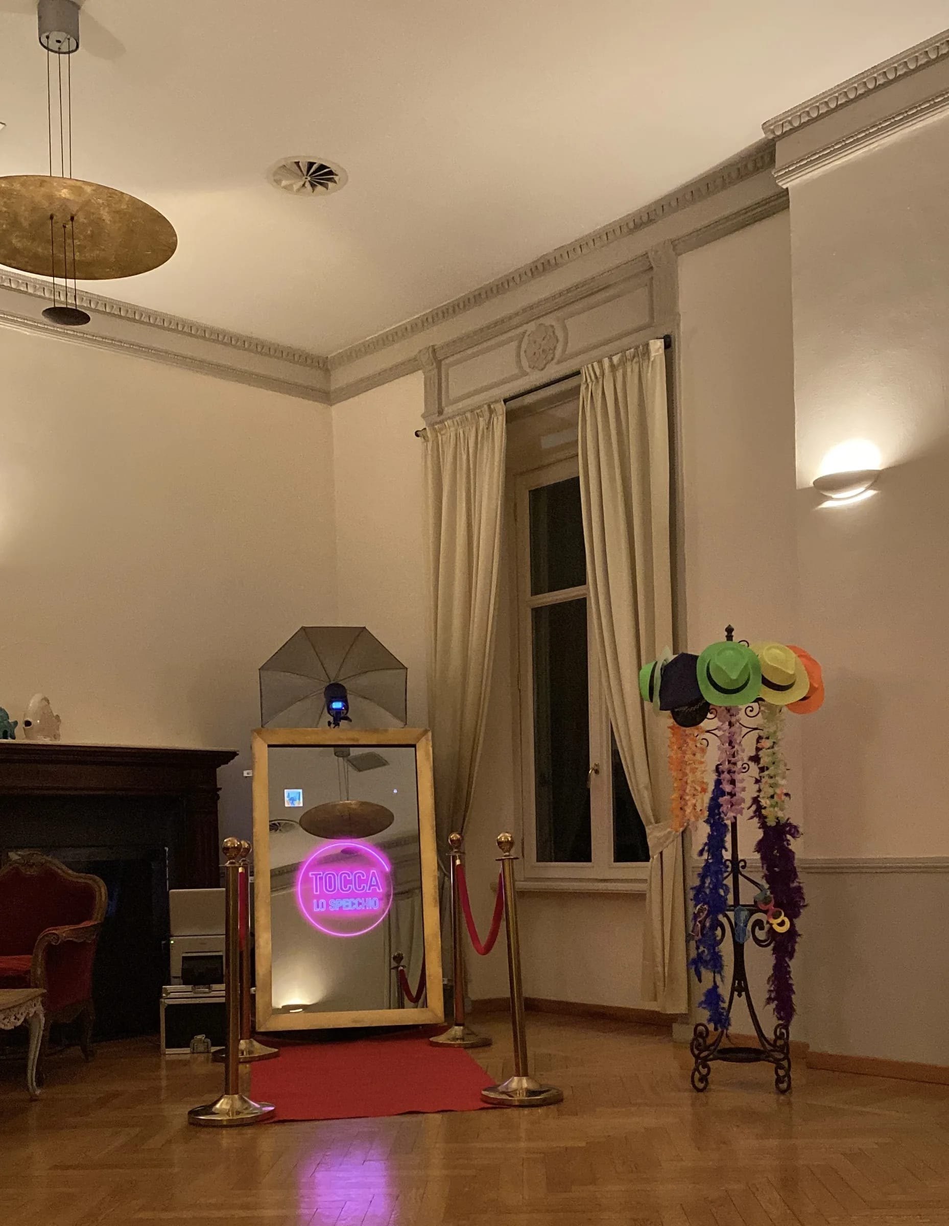 Specchio selfie allestito in una sala, con tappeto rosso e accessori