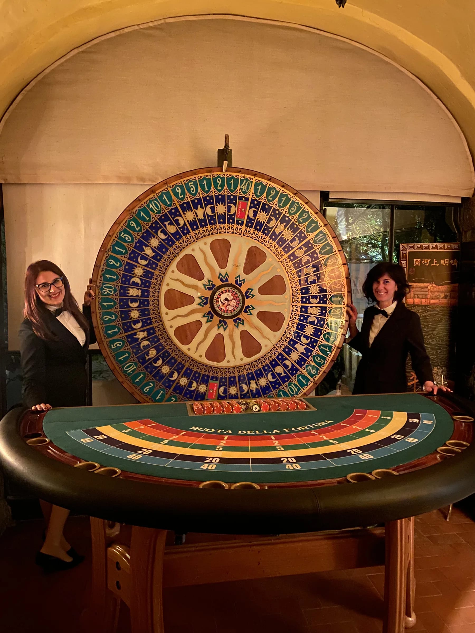 Due croupier accanto alla ruota della fortuna