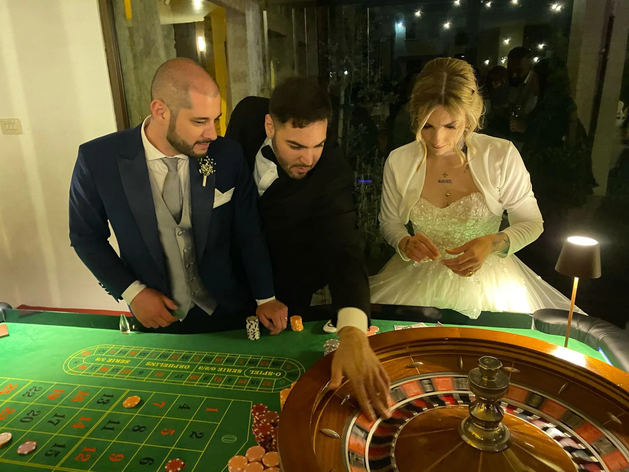 Sposa e sposo con il croupier al tavolo da roulette