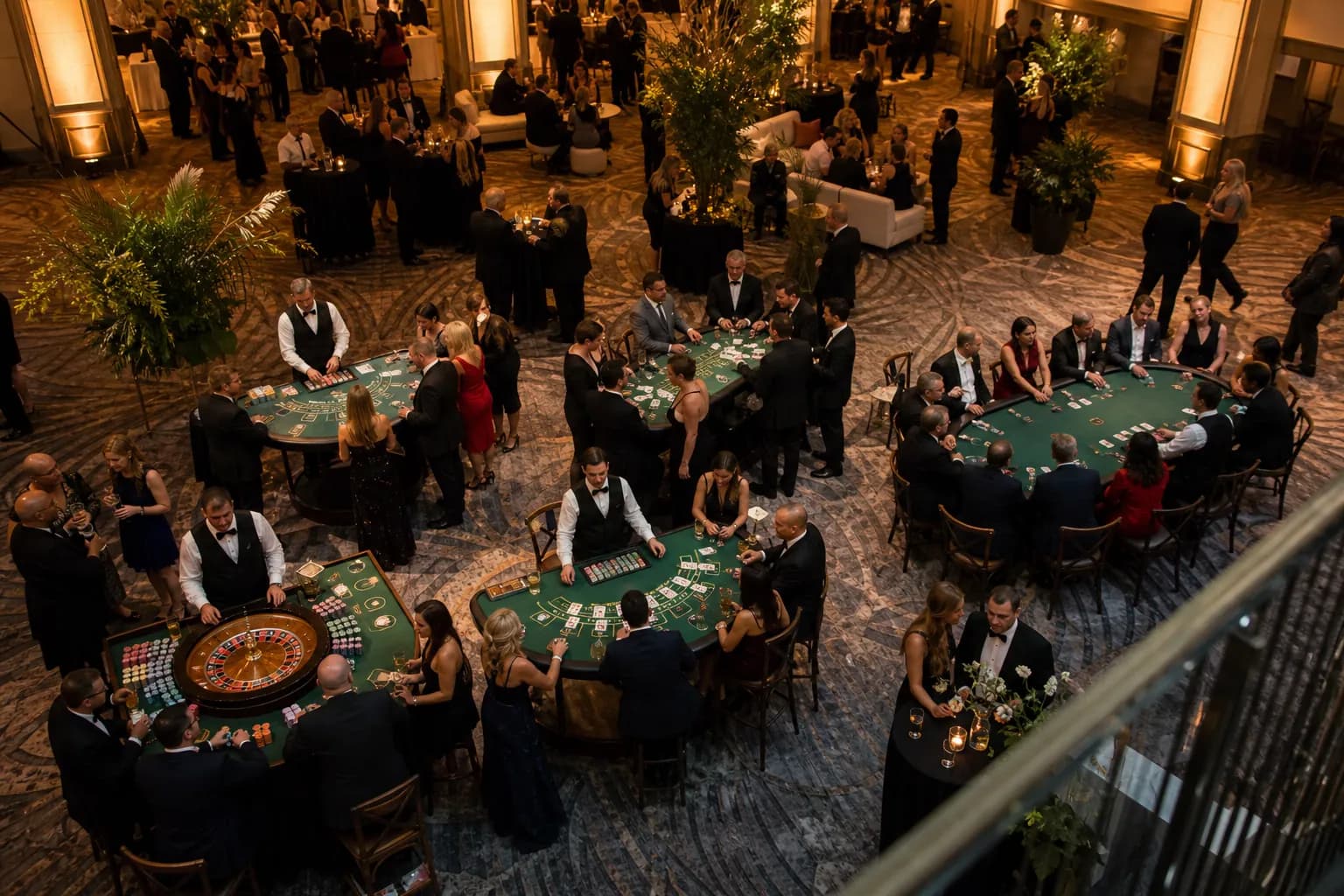 Sala da evento con più tavoli da casinò, croupier e ospiti durante un Casino Party